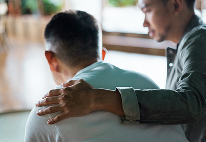 grieving end of life care training image of son comforting father by project compassion
